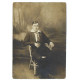 1915 - Muž sediaci na stoličke, čiernobiela fotopohľadnica, Rakúsko Uhorsko